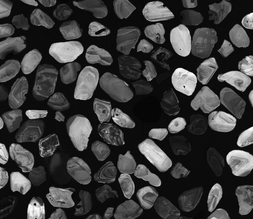 Scanning electron microscope image of zircon crystals. Each crystal is about 0.1 millimeters in size, which is roughly the thickness of a human hair, and records cosmogenic krypton as a geochemical time archive.  Photo: Maximilian Dröllner 