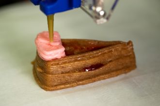 Peanut butter being deposited onto a layer of graham cracker paste