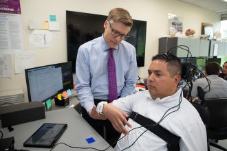 Dr. Chad Bouton assists setting up Keith Thomas