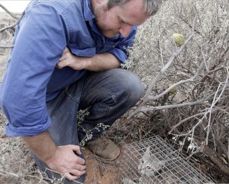 Dr Hugh McGregor and a feral cat trapped in arid SA