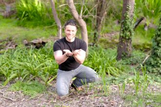 Jake Robinson holds soil leaf litter which is critical to human health