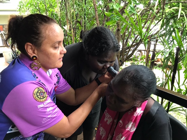 Sissy Tyson assisting Audrey Kerinauia to assess Aileen Tiparui with an otoscope