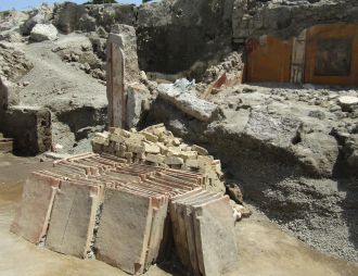 Rows of ceramic roof tiles and a stack of yellow tuff blocks