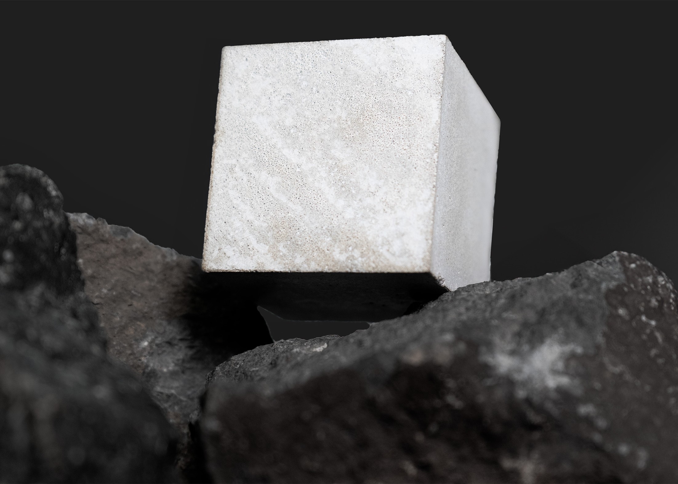A cube of Portland cement produced from silicate rocks on top of some silicate rocks. Credit: Brimstone Energy.