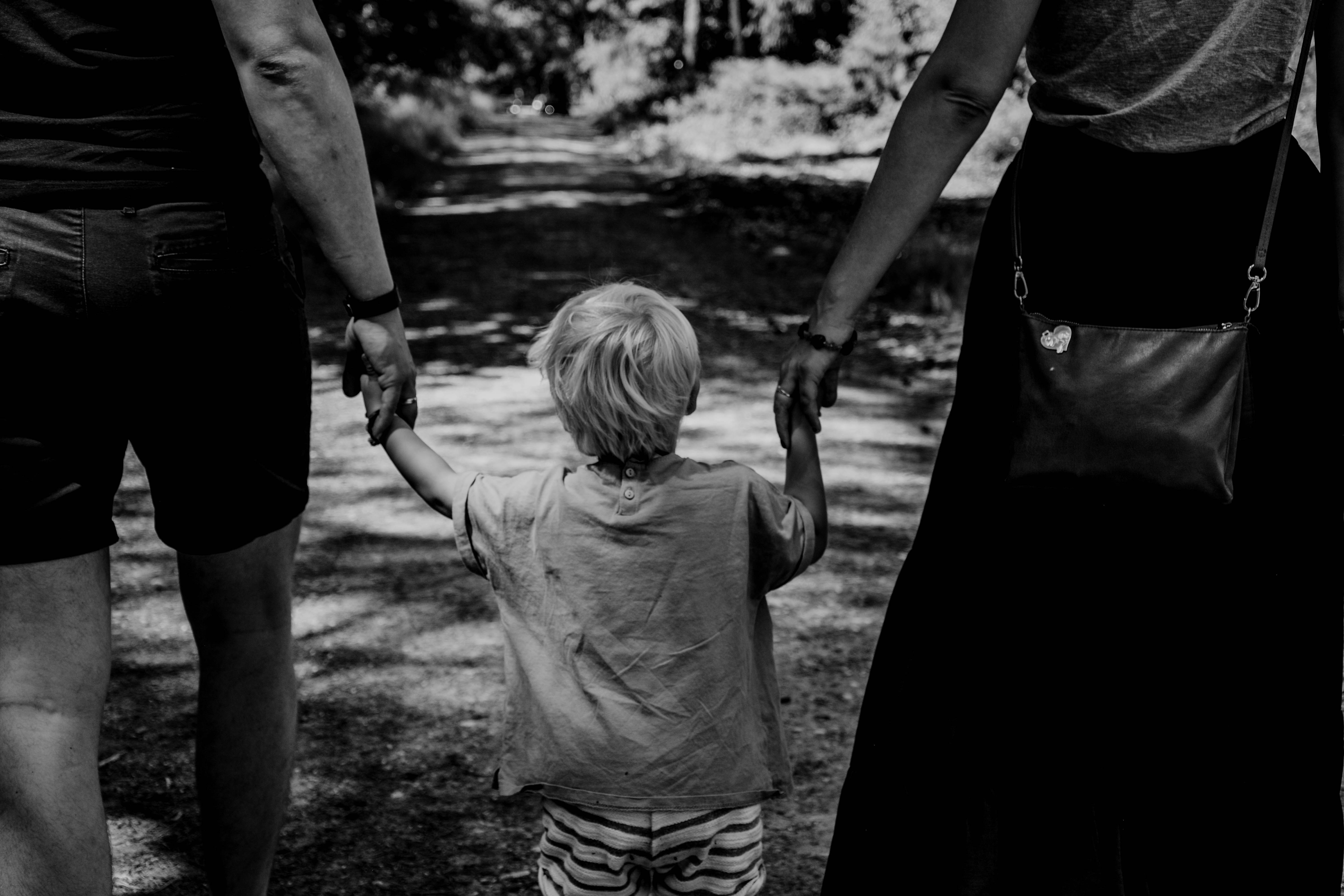 CC-0. https://unsplash.com/photos/grayscale-photo-of-woman-in-black-dress-holding-child-in-black-shirt-JDqYwfKPzEs