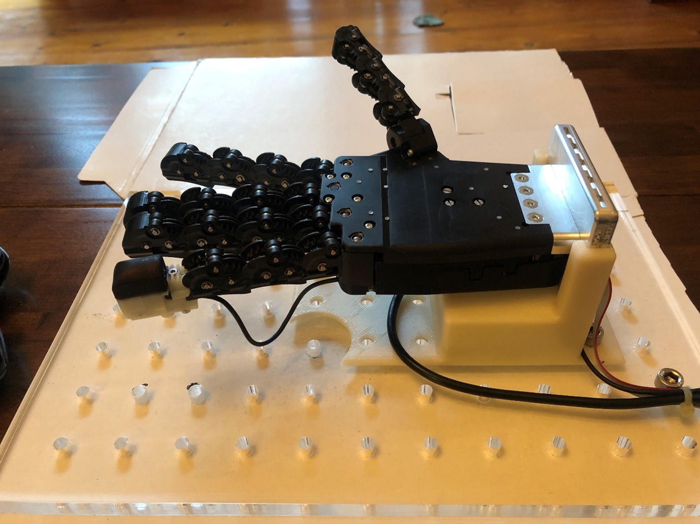 Robotic hand with a 3D-printed tactile fingertip on the little (pinky) finger. The white rigid back to the fingertip is covered with the black flexible 3D-printed skin.  CREDIT: Nathan Lepora