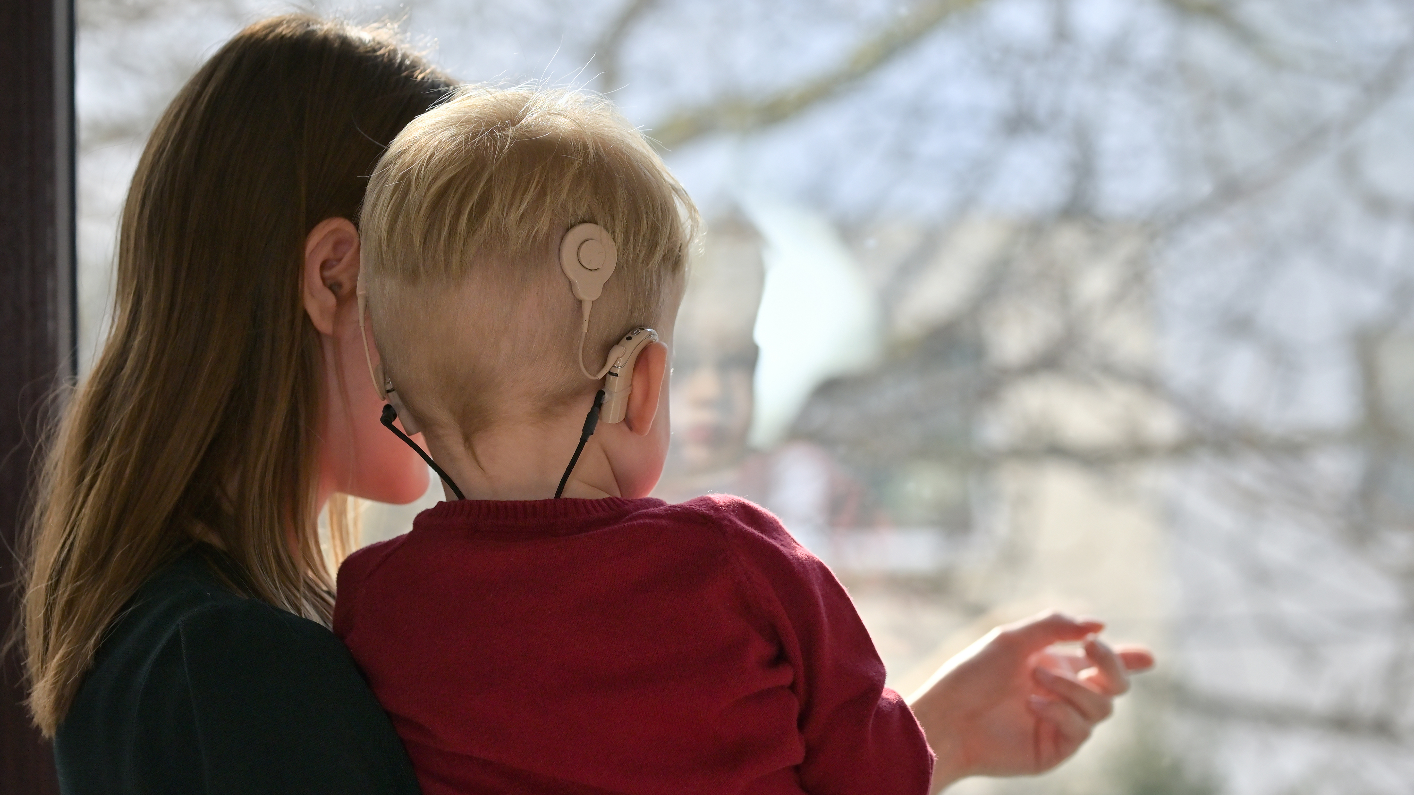 Shutterstock generic image of mother and child with cochlear implant.