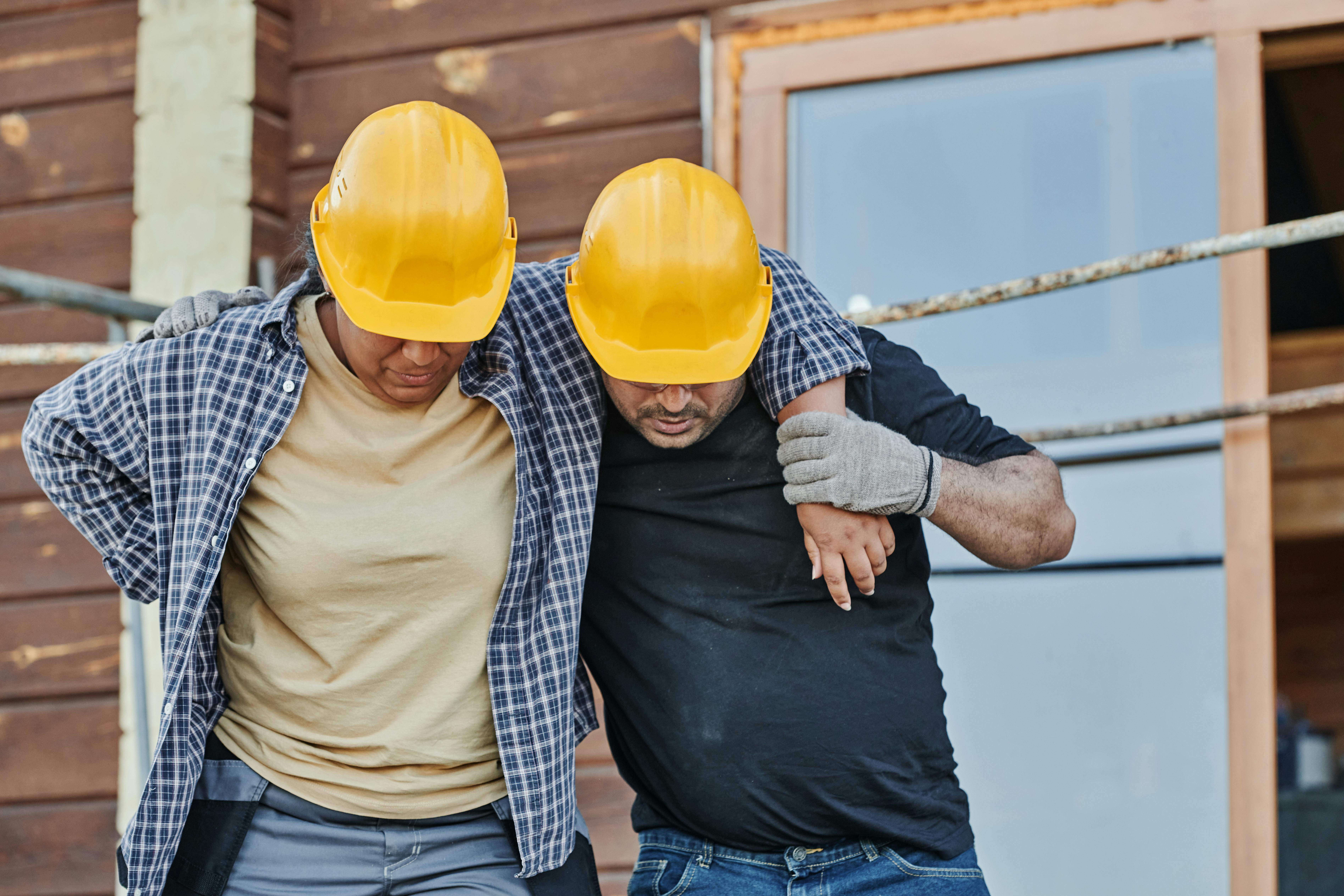 CC-0. https://www.pexels.com/photo/a-worker-supporting-an-injured-co-worker-8961551/