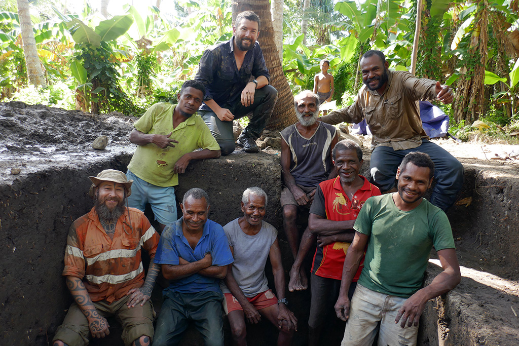 The team on Brooker Island in the water is from front to back: Simon Coxe (archaeologist, Monash University), Kenneth Miamba (chief archaeologist, National Museum and Art Gallery of Papua New Guinea), Dr Ben Shaw, and Vincent Kewibu (lecturer in archaeology, University of Papua New Guinea). 