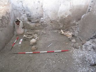 Individual 2 huddled on his left side with his left hand protecting his head