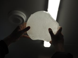 A student holds an ice core up to a light