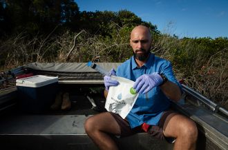 Dr Maarten de Brauwer collects a water sample at Yamba on the NSW North Coast.