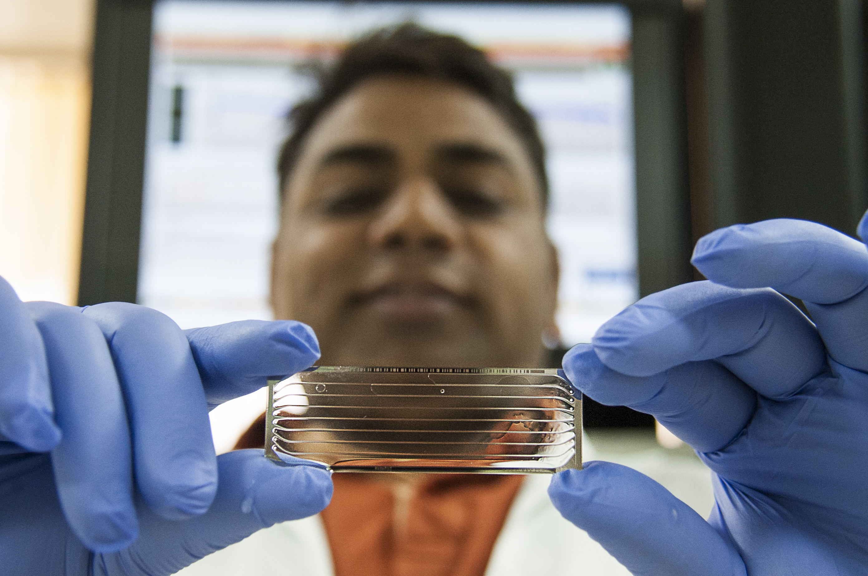 Professor Varshney holds up a flow cell for genome sequencing
