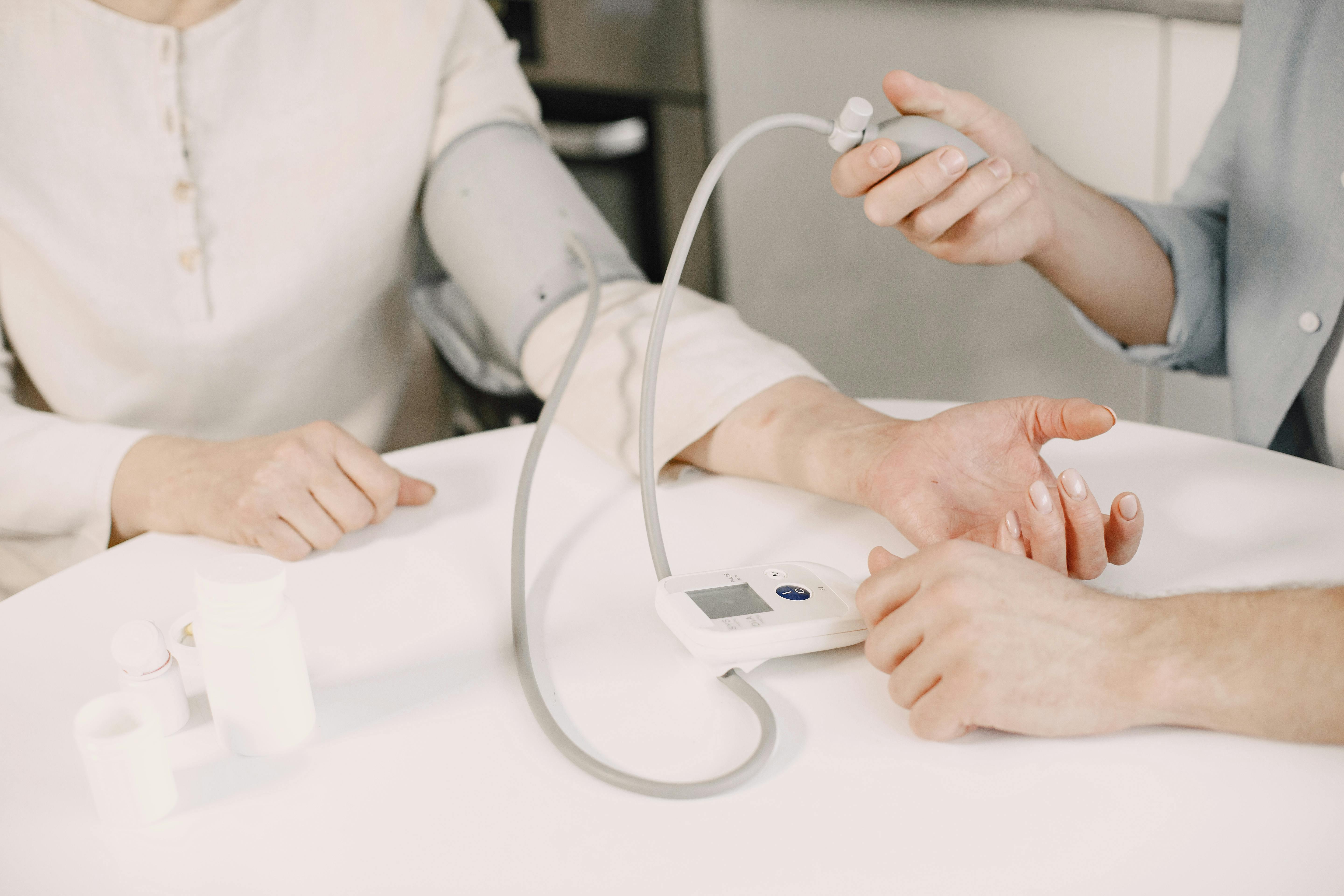 CC-0. https://www.pexels.com/photo/close-up-of-man-measuring-blood-pressure-of-a-woman-using-a-blood-pressure-monitor-at-home-7446776/