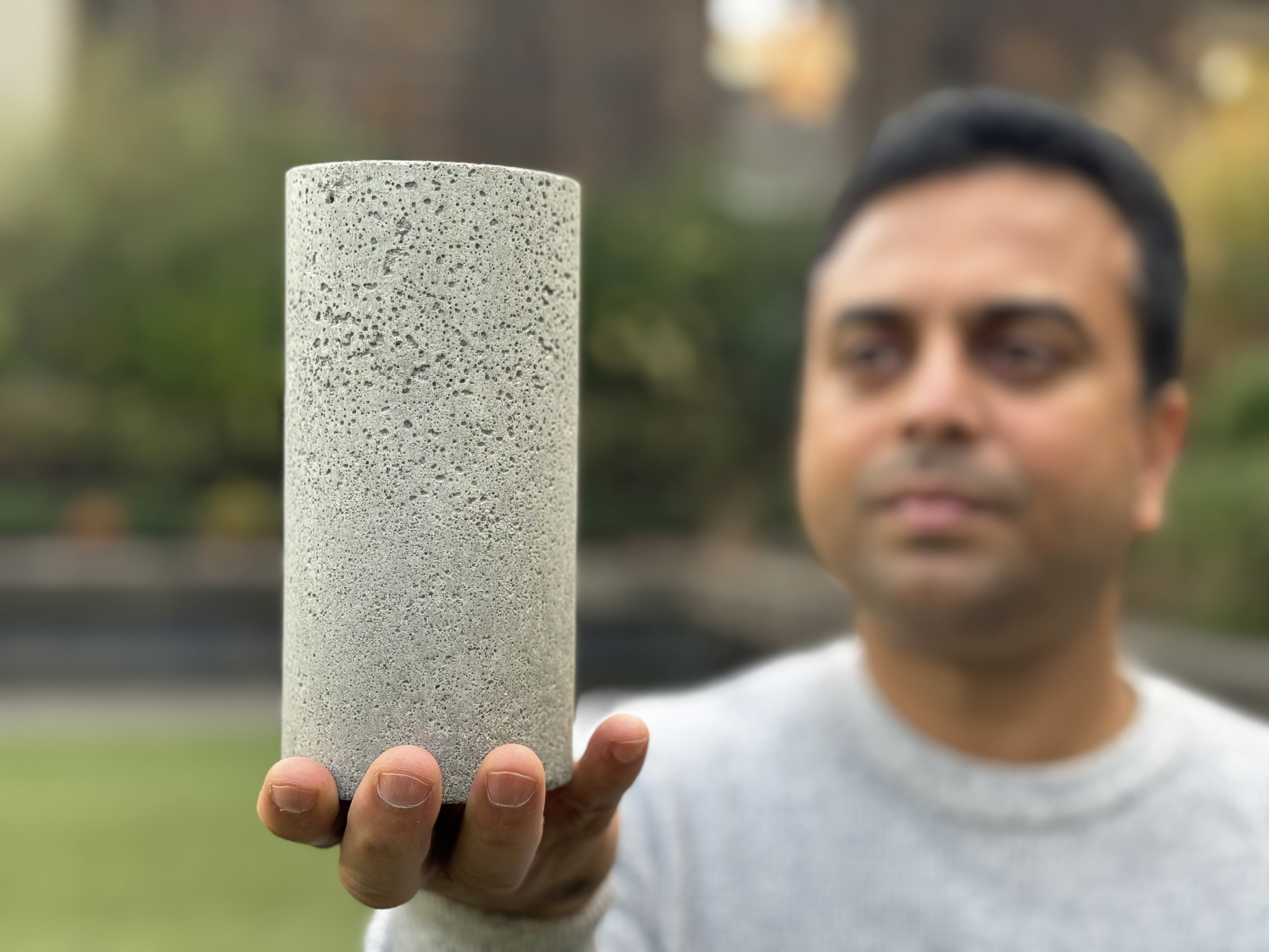 Dr Chamila Gunasekara holds a sample of the low-carbon concrete. Credit: Michael Quin, RMIT.
