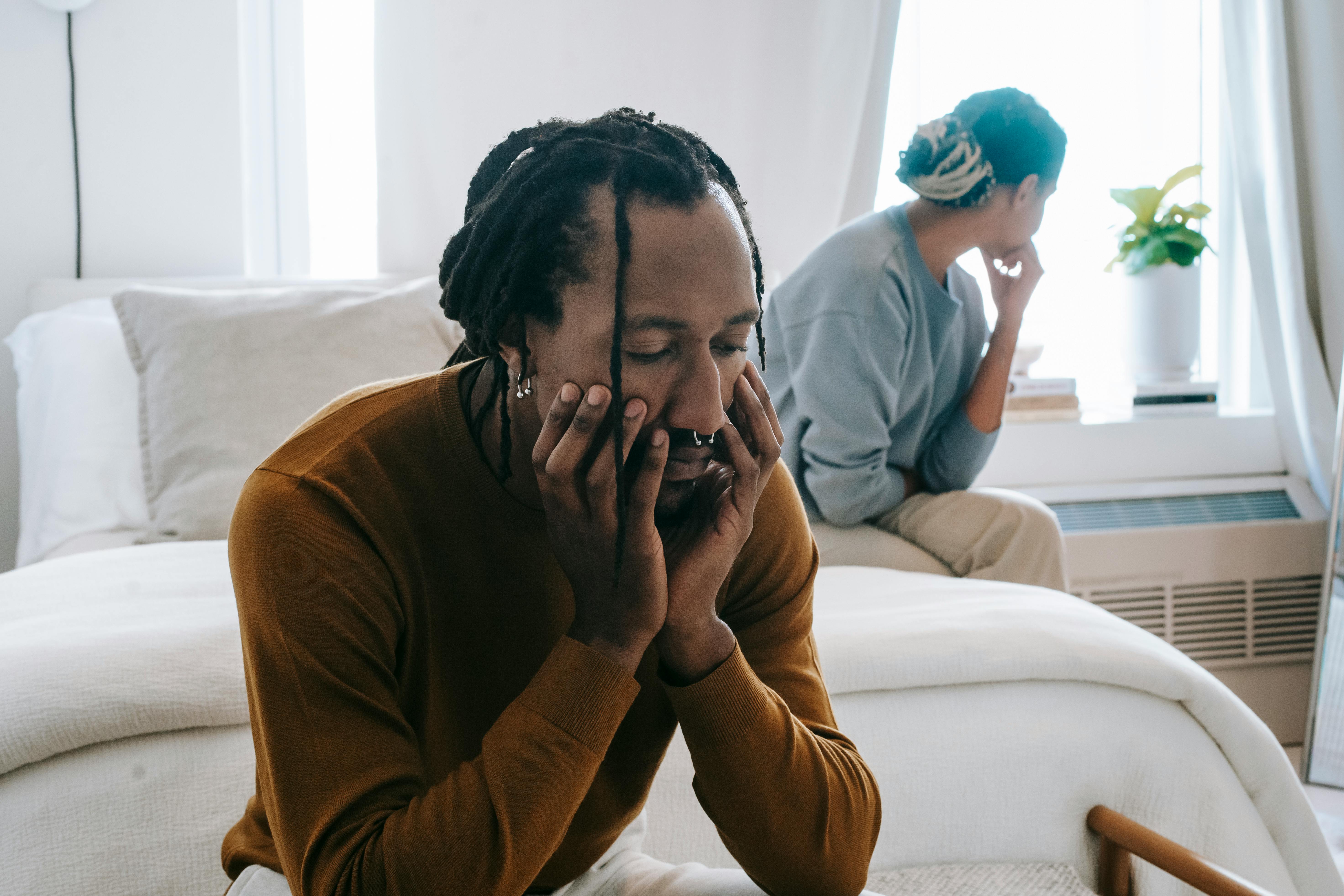 CC-0. https://www.pexels.com/photo/african-american-couple-resting-on-bed-with-sad-face-5699737/