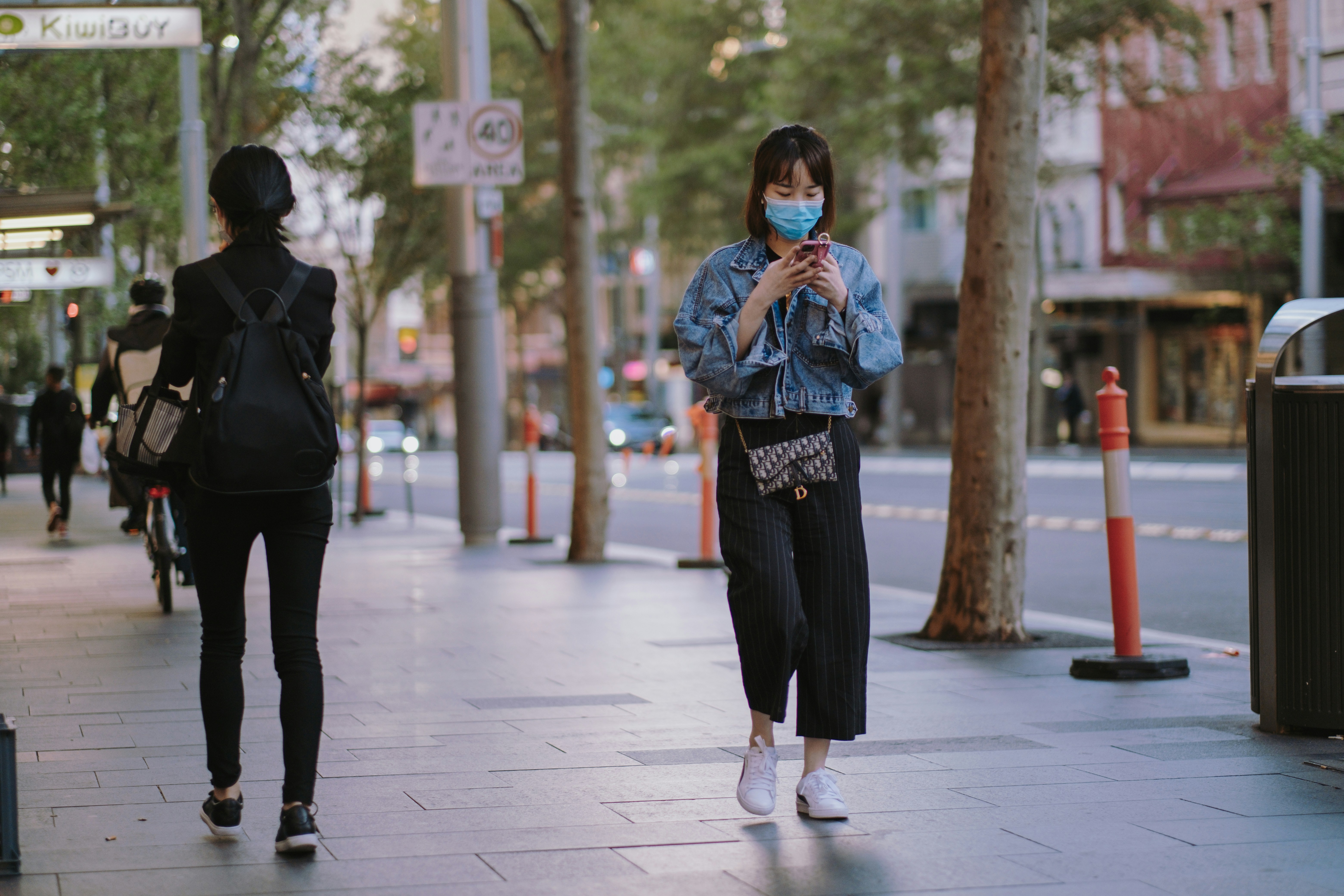 Woman in face mask walking down the street during a coronavirus lockdown in Sydney. Photo by Kate Trifo on Unsplash