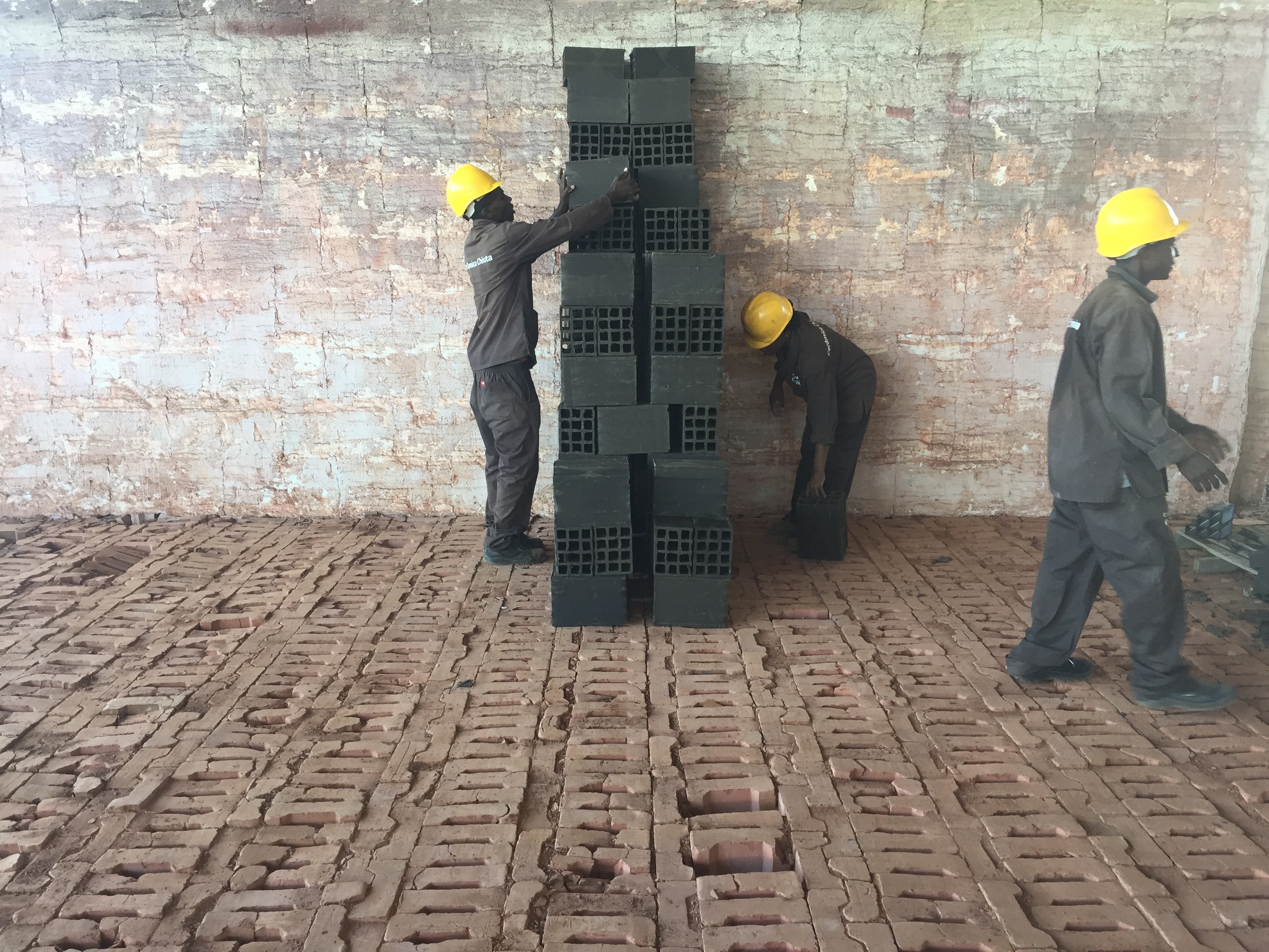 Workers stack clay bricks in a kiln in preparation for firing, Mozambique, credit: Daniel Franks