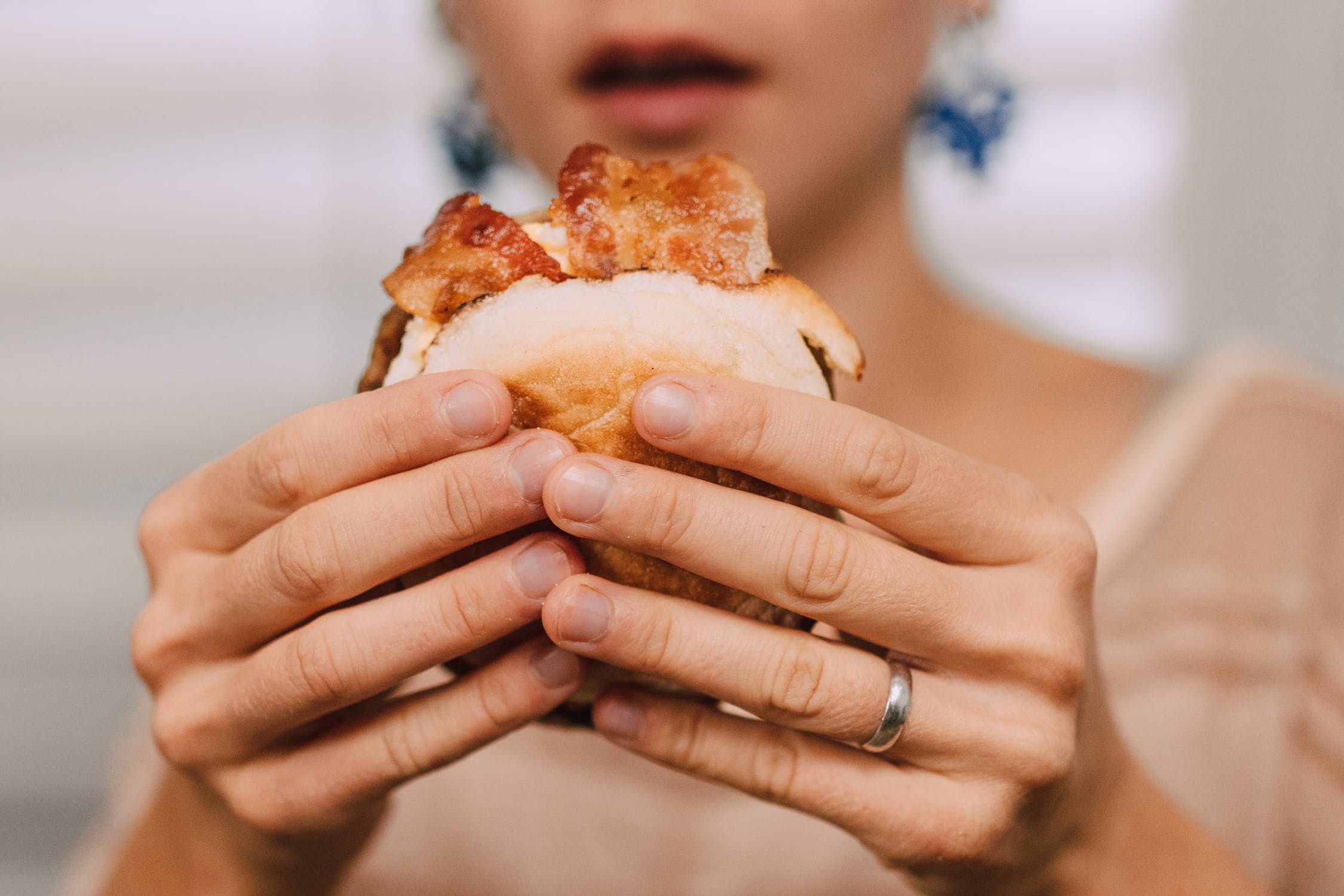 Gen Z eating a burger, Pexels.