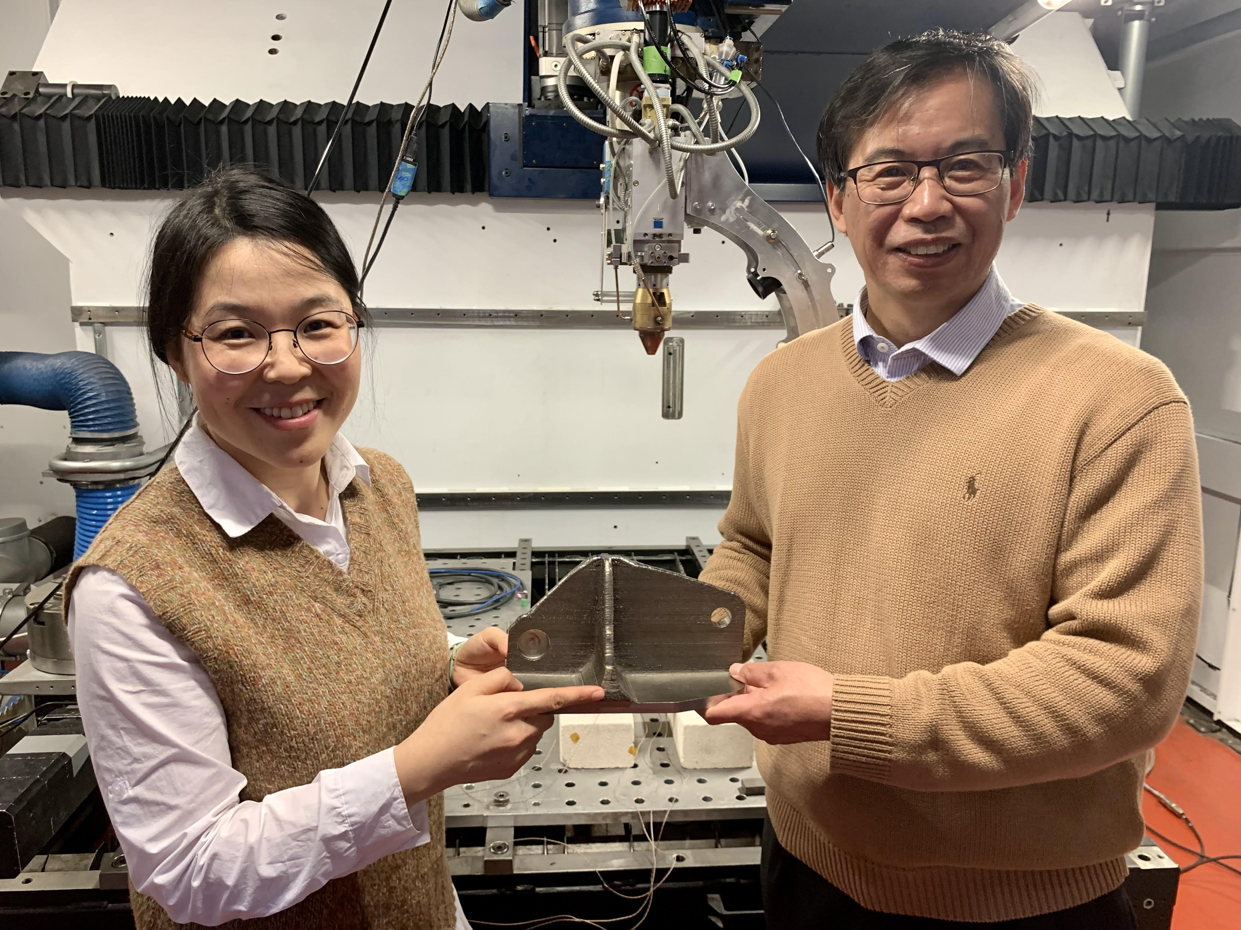 Tingting Song and Ma Qian (left to right) with a titanium alloy created with the laser 3D printer that the team used at RMIT University (note this is not an alloy that the team made for this research). Credit: RMIT University