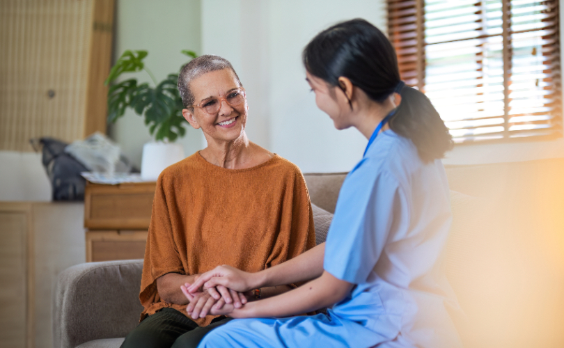 Caregiver holding hands with patient. Image: Adobe Stock by Natee Meepian.