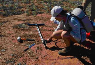 Ruby Hume taking soil samples in the field.