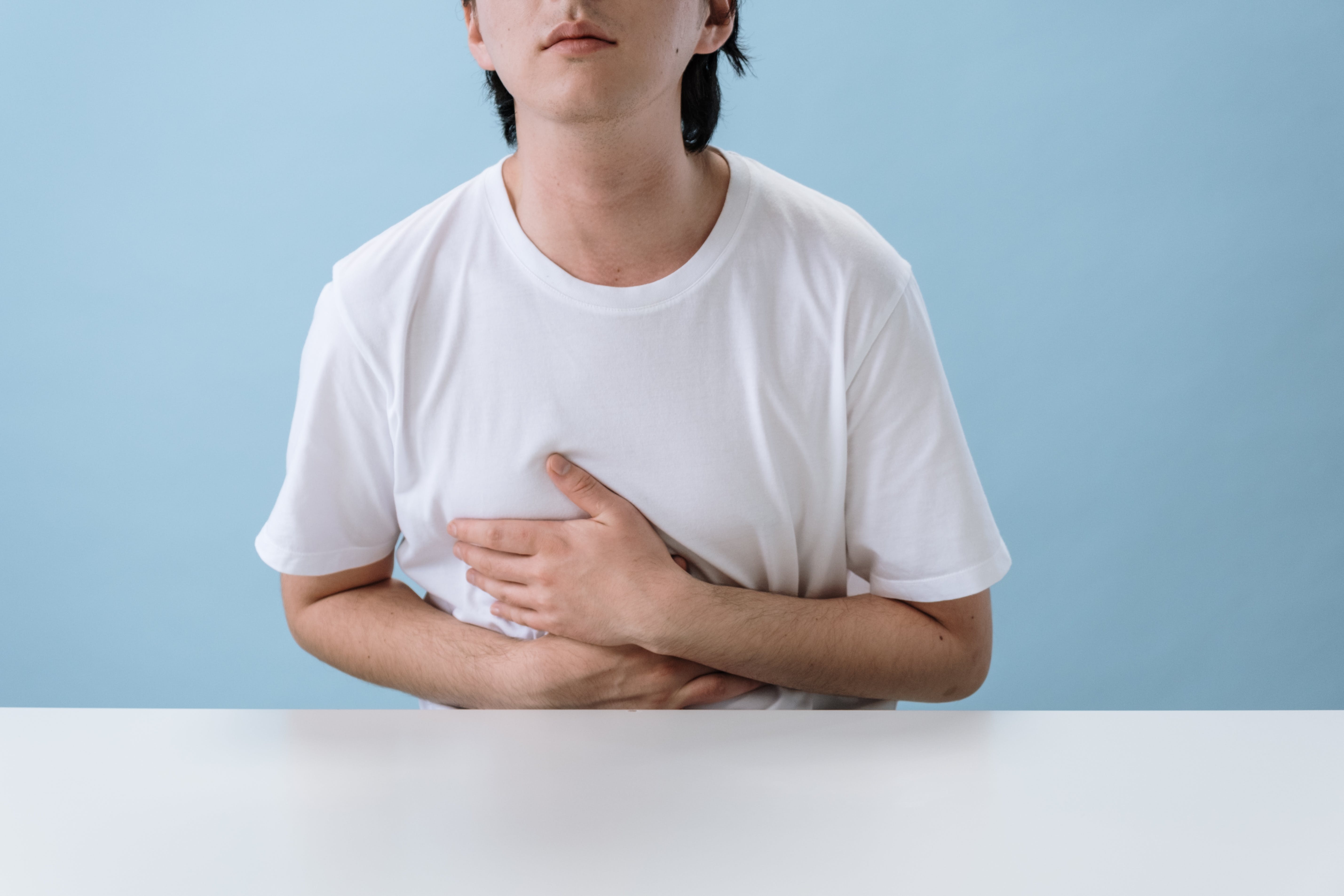 CC-0. https://www.pexels.com/photo/man-in-white-shirt-suffering-from-a-stomach-pain-5712686/