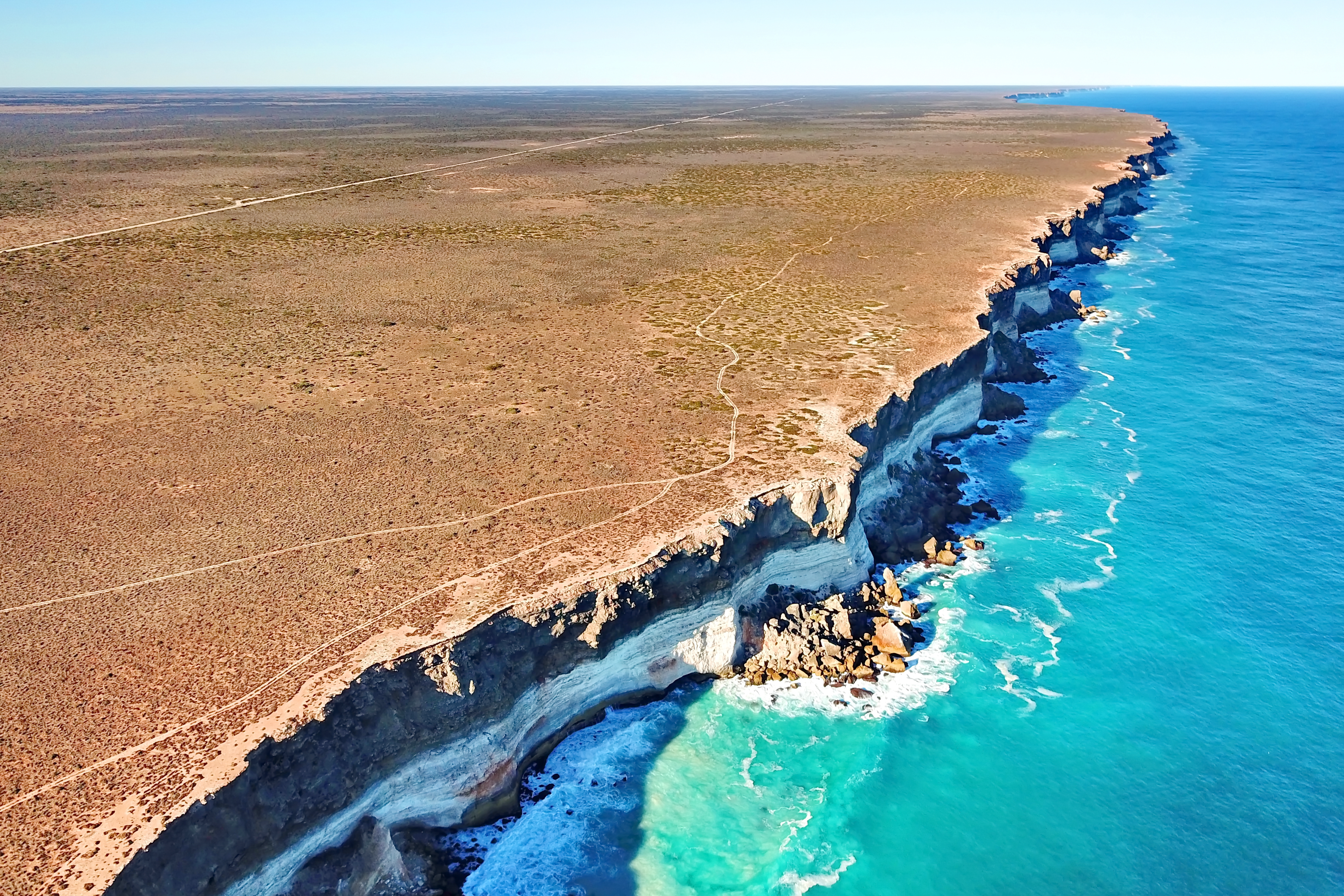 •	‘Nullarbor Plain’ - Drone image of the Bunda Cliffs, where the Nullarbor Plain meets the Great Australian Bight. Layering in the cliffs represent different limestone units. Photo courtesy of Dr Matej Lipar.