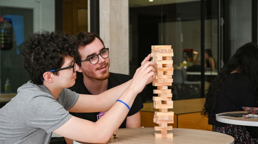 Two white, male university students playing Jenga.