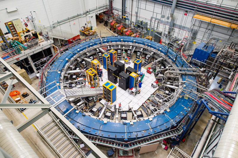 First results from the Muon g-2 experiment at Fermilab have strengthened evidence of new physics. The centerpiece of the experiment is a 50-foot-diameter superconducting magnetic storage ring, which sits in its detector hall amidst electronics racks, the muon beamline, and other equipment. This impressive experiment operates at negative 450 degrees Fahrenheit and studies the precession (or wobble) of muons as they travel through the magnetic field. Photo: Reidar Hahn, Fermilab