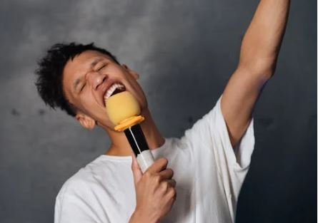 CC-0. https://www.pexels.com/photo/man-in-white-t-shirt-holding-microphone-7886987/