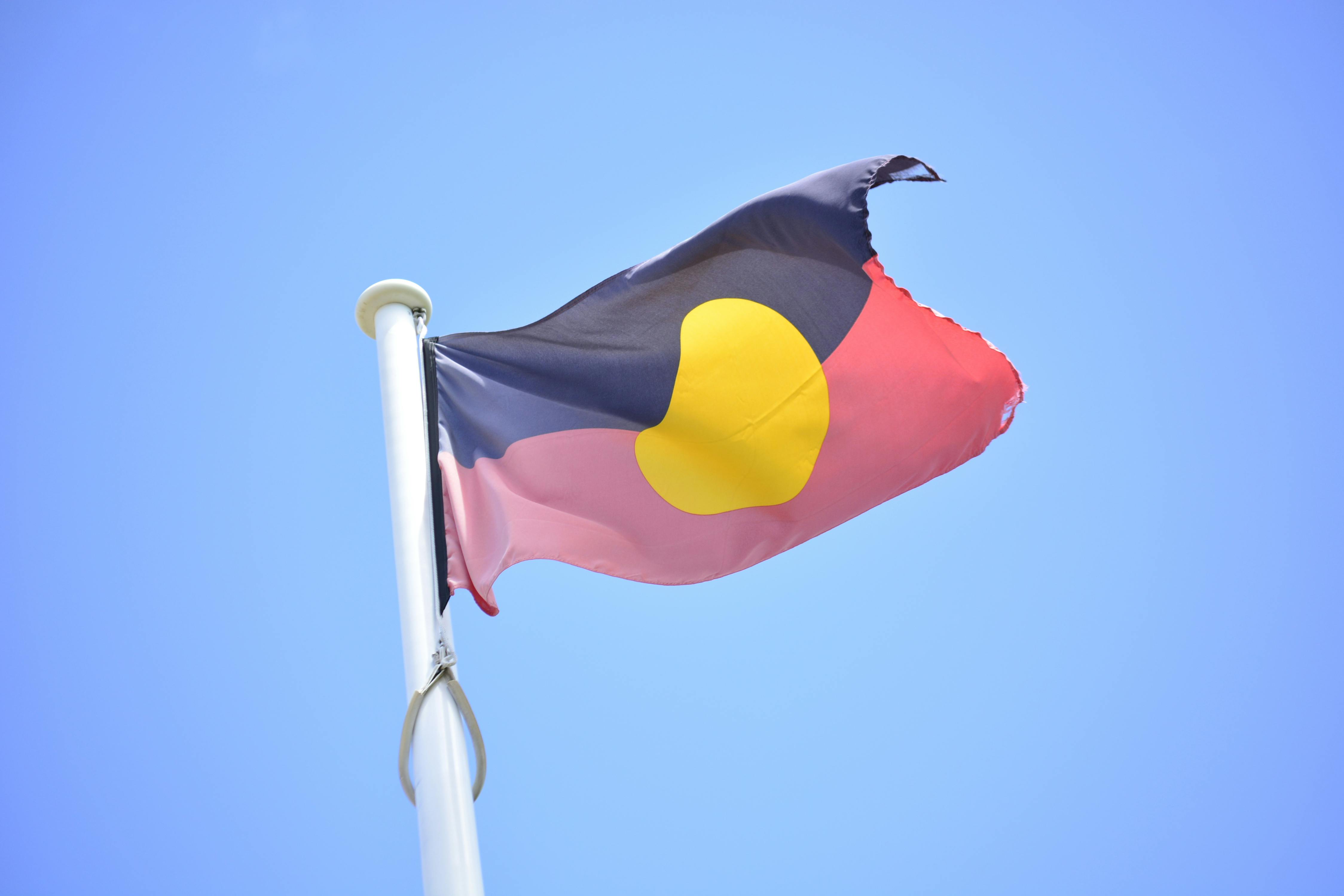CC-0. https://www.pexels.com/photo/australian-aboriginal-flag-against-clear-blue-sky-28840846/