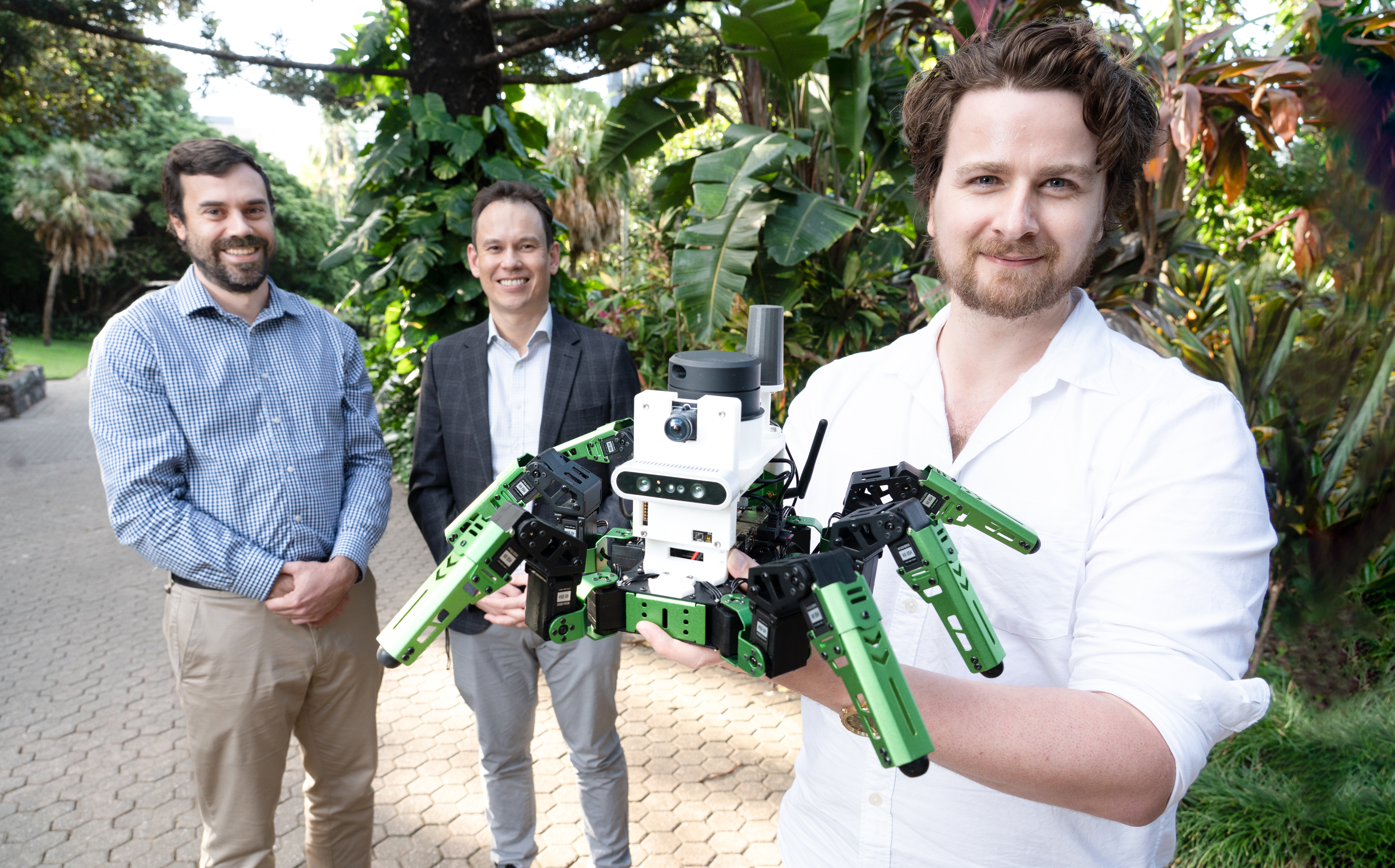 QUT Dr Adam Hines, with his 'green' robot. l/r-  Dr Tobias Fischer, Dr Adam Hines and Professor Michael Milford.