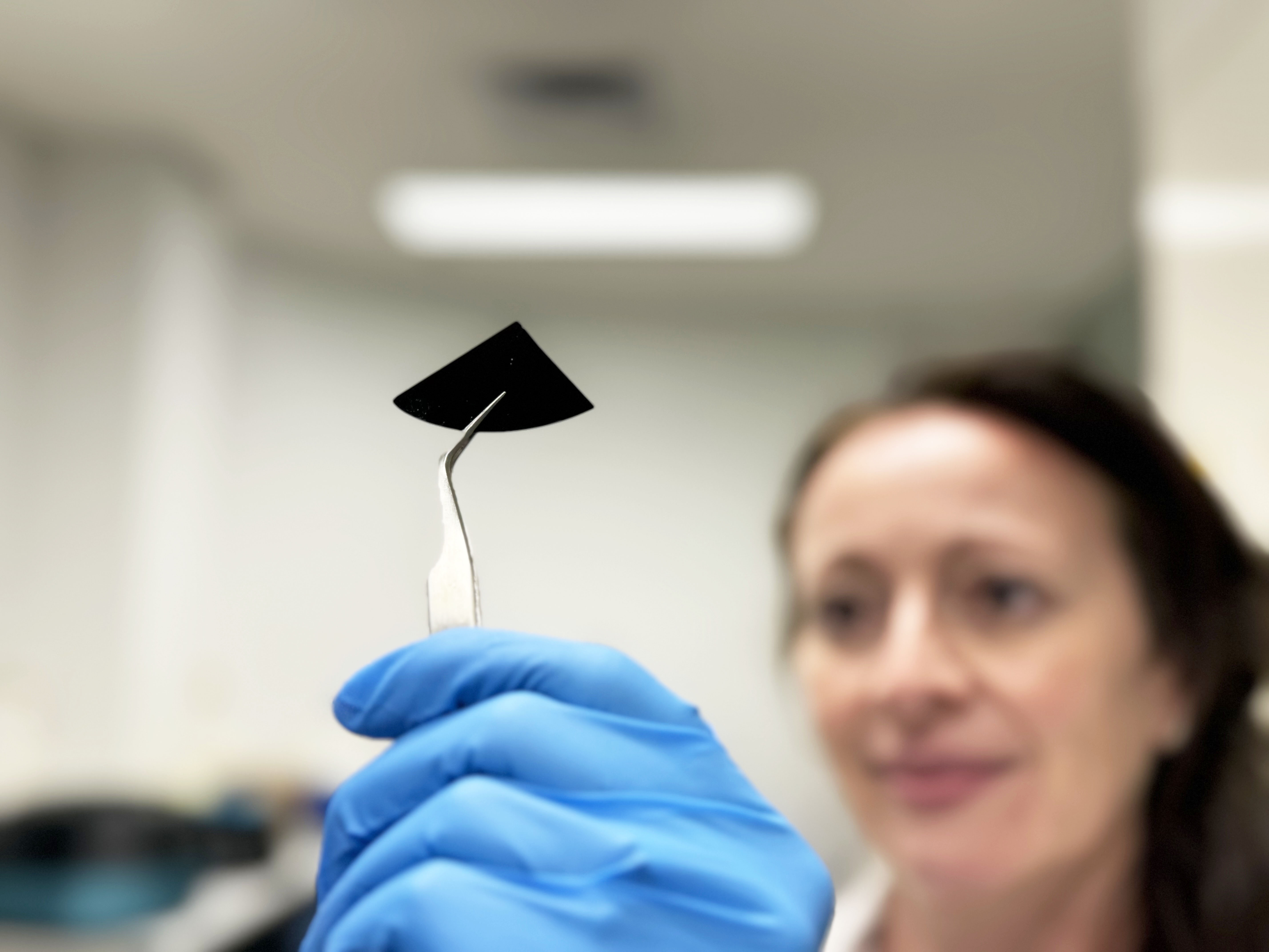 Dr Natalie Borg inspects a sample of the nano spiked silicon sheet. Credit: RMIT.