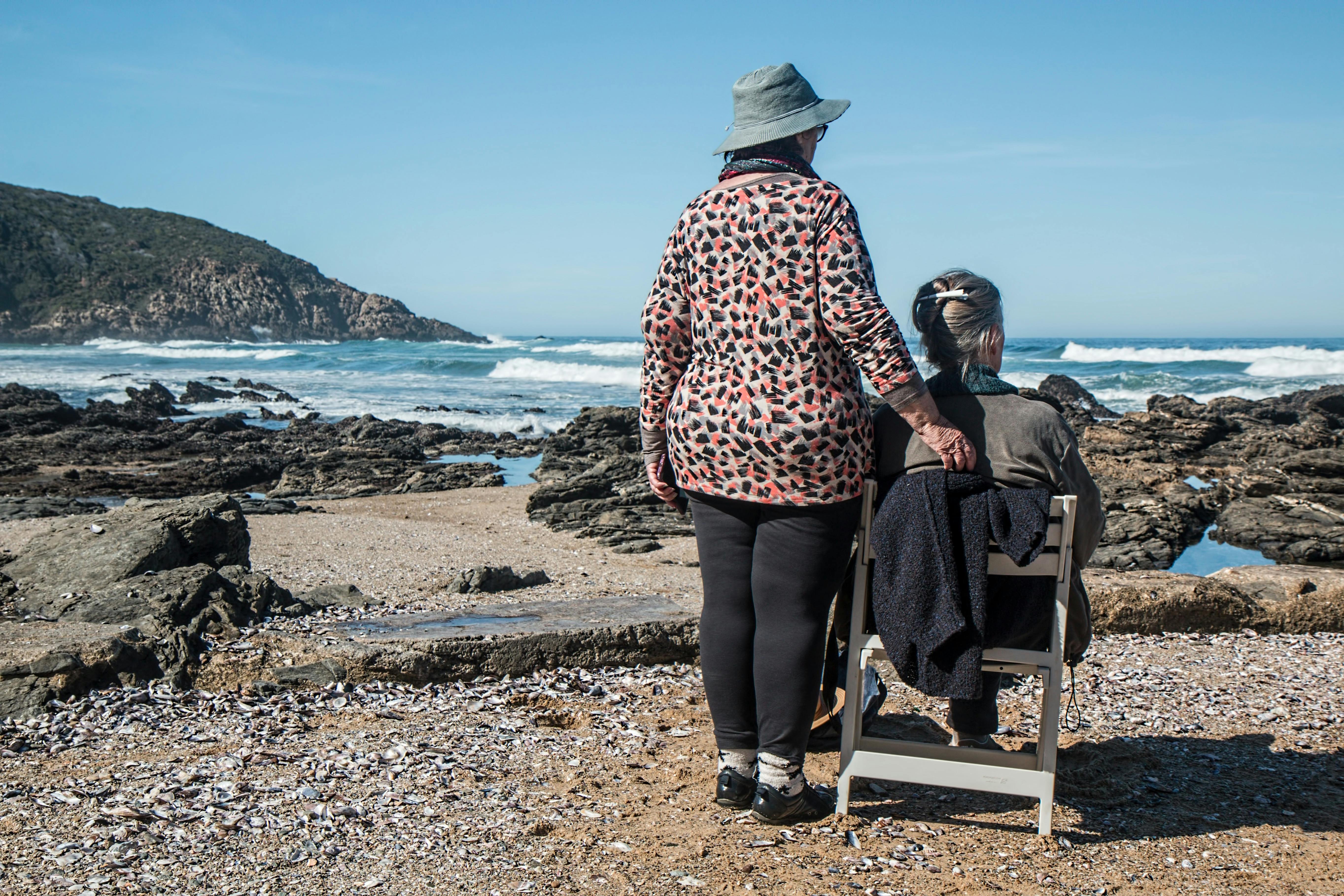 Two older women facing the ocean