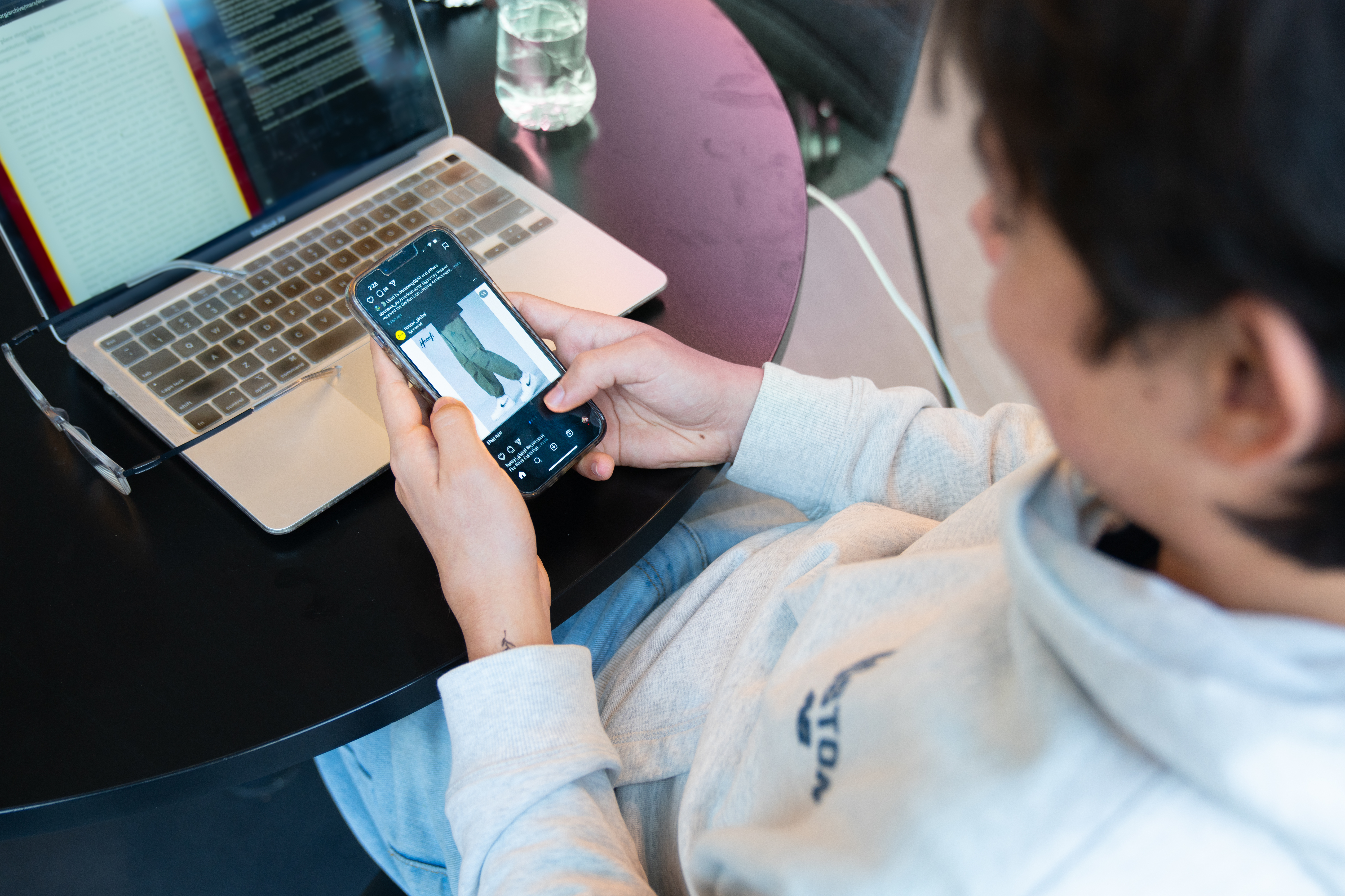 A student scrolling Instagram on their phone. Credit: Jack Fox/ANU