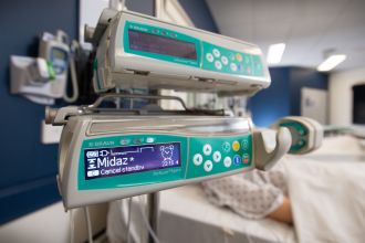 Midazolam name shows on syringe infusion pump.