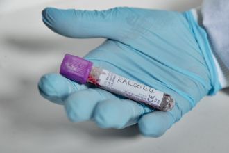Professor Vanessa Hayes holding a vial containing a blood sample