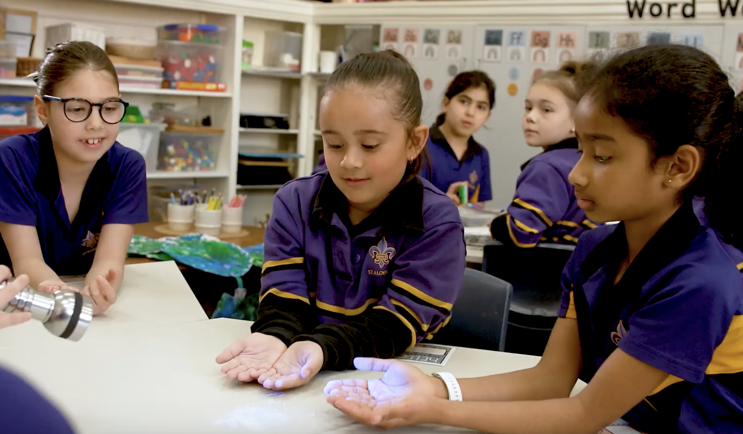 School children doing the Glitterbug experiment with UV light