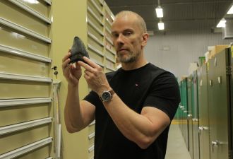 Dr Mikael Siversson holding tooth of megalodon shark