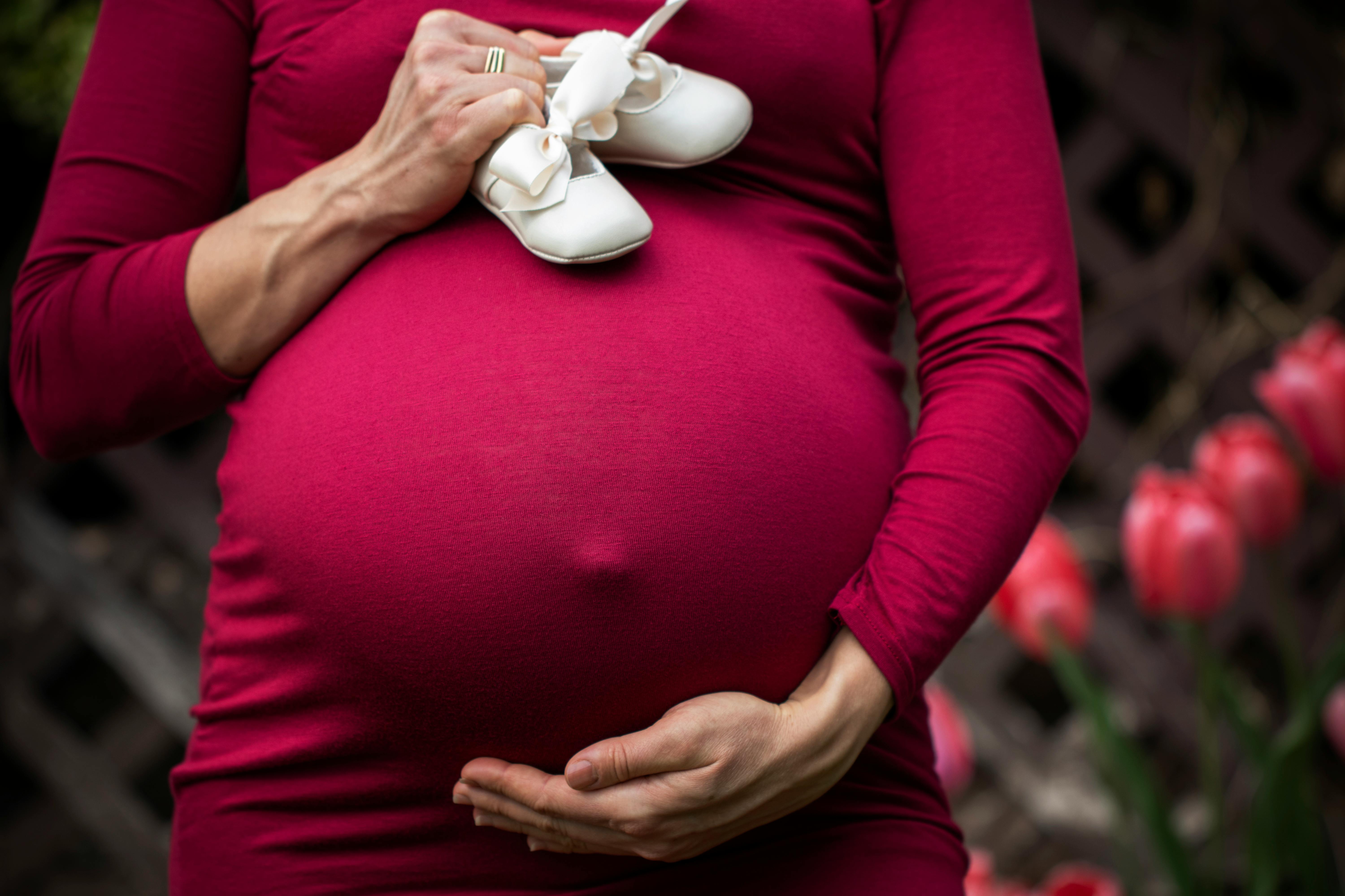 CC-0. https://www.pexels.com/photo/pregnant-woman-holding-baby-s-shoes-2617210/